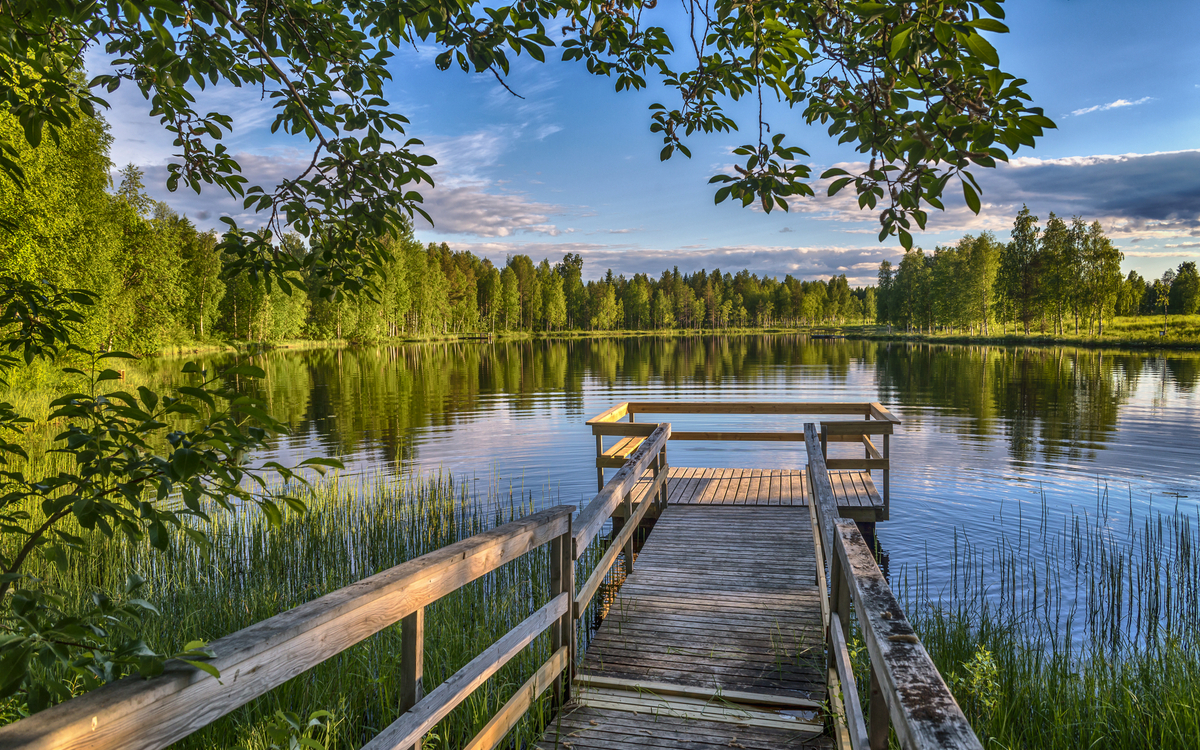 Pier mit Holzbänken am See in Lappland